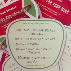 Apple shaped note cards with handwriting. The writing describes activities the person does to take care of their mind.