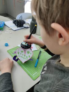 A boy decorating a glass gratitude jar.