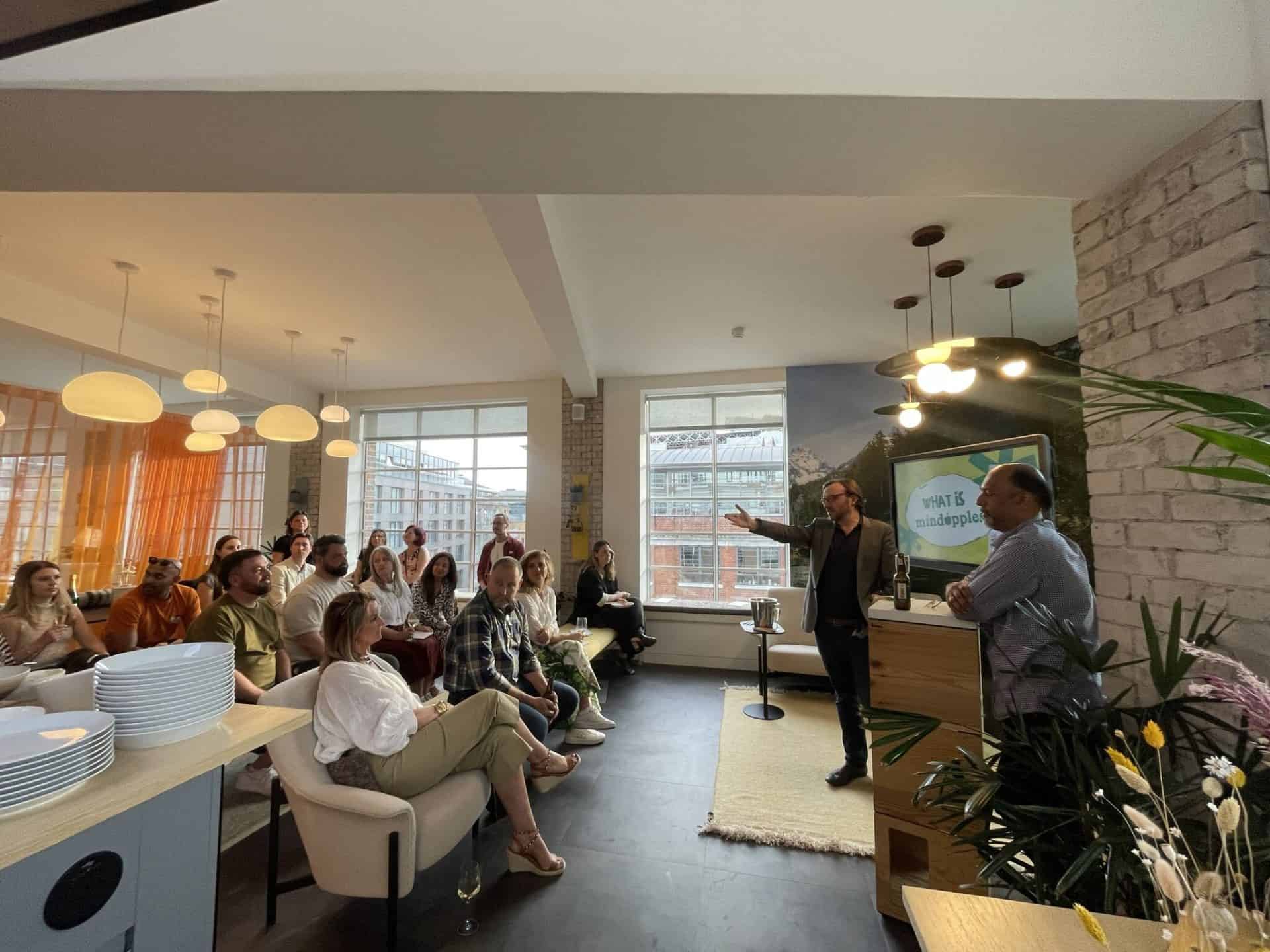 A group of people sitting in a room with a man giving a presentation.